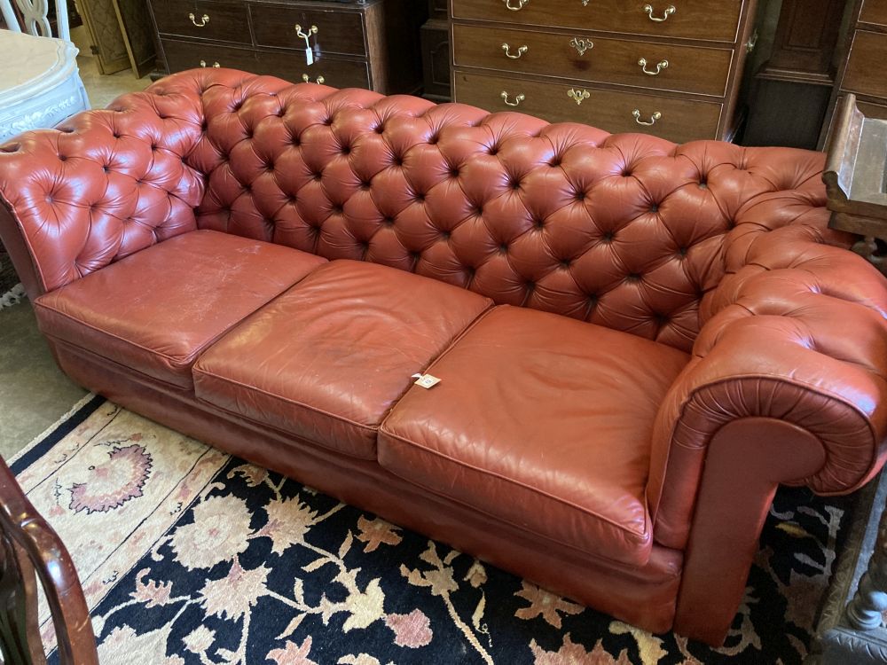 A three seater buttoned red leather chesterfield settee, length 210cm, depth 90cm, height 68cm